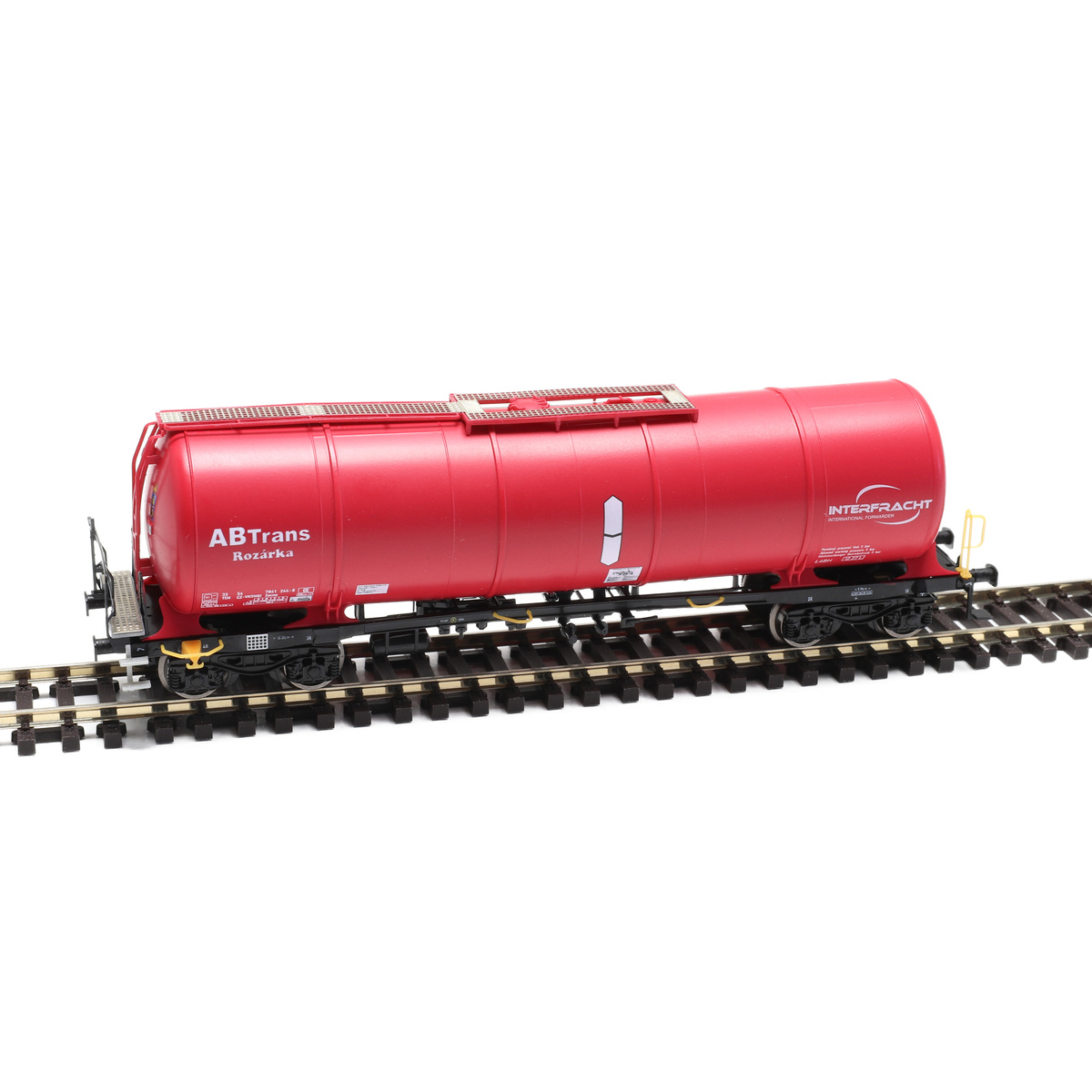 H0 scale four-axle Czech tank wagon AB Vagon Trans Rozarka on a realistic modern freight railway layout, industrial fuel terminal in the background, soft natural daylight, highly detailed model railway scene